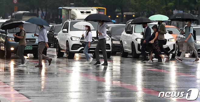 전국 곳곳에 비소식이 찾아온 3일 오전 서울 종로구 광화문 네거리에서 우산을 쓴 시민들이 출근길 발걸음을 재촉하고 있다. 기상청은 이날 전국이 기압골의 영향을 받다가 차차 벗어나겠다고 예보했다. 2022.8.3/뉴스1 ⓒ News1 민경석 기자