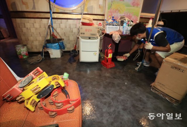 15일 지난주 집중호우로 수해피해를 입은 서울 동작구 상도동의 한 노래방에서 자원봉사자가 물기를 제거하고 있다.