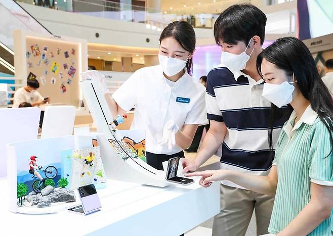 지난 13일 서울 영등포 타임스퀘어 갤럭시 스튜디오 방문객들이 갤럭시 팬큐레이터의 안내를 받아 ‘갤럭시Z 플립4’의 플렉스 캠을 체험해보고 있다. 삼성전자 제공