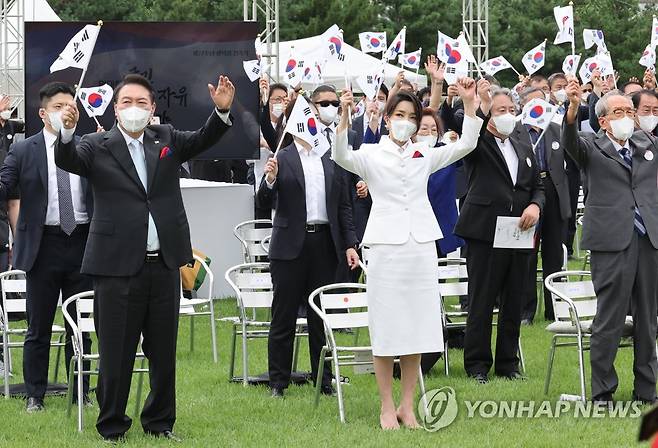 만세삼창하는 윤석열 대통령 내외 (서울=연합뉴스) 안정원 기자 = 윤석열 대통령과 김건희 여사가 15일 서울 용산 대통령실 청사 잔디마당에서 열린 제77주년 광복절 경축식에서 만세삼창을 하고 있다. 2022.8.15 jeong@yna.co.kr