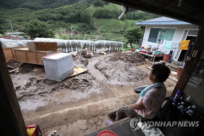 망연자실 수재민 (부여=연합뉴스) 강수환 기자 = 15일 오전 충남 부여군 거전리 정골마을에서 전날 새벽에 집중적으로 내린 폭우로 인한 산사태로 망가진 집을 한 주민이 내려다보고 있다. 2022.8.15 swan@yna.co.kr
