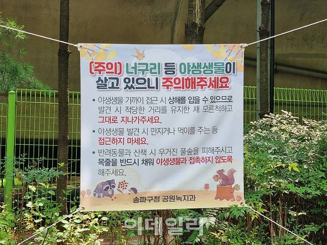 지난달 산책하던 시민이 야생너구리에게 공격당한 사고가 발생한 서울 송파구 장지공원에 ‘야생너구리 주의’ 현수막이 걸려 있다.(사진=조민정 기자)