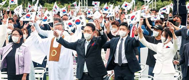 윤석열 대통령과 부인 김건희(맨 앞줄 오른쪽) 여사가 15일 서울 용산 대통령실 잔디마당에서 열린 제77주년 광복절 경축식에서 참석자들과 함께 만세 삼창을 하고 있다. 윤 대통령은 이날 경축사에서 “우리의 독립운동은 끊임없는 자유 추구의 과정으로, 앞으로도 계속될 것”이라며 “세계 평화와 번영에 책임 있게 기여하는 것이야말로 독립운동에 헌신하신 분들의 뜻을 이어가고 지키는 것”이라고 했다. /뉴시스