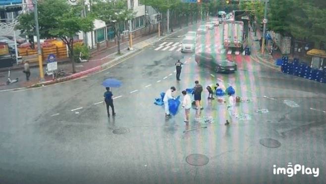 지난 6월29일 도로에 쏟아진 맥주병을 치우는 시민들/ 사진=춘천시 제공