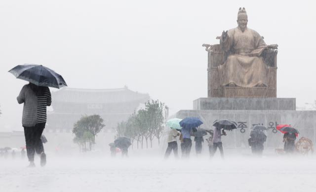 많은 비가 내린 지난 8일 우산을 쓴 시민들이 서울 광화문광장을 지나고 있다. 연합뉴스