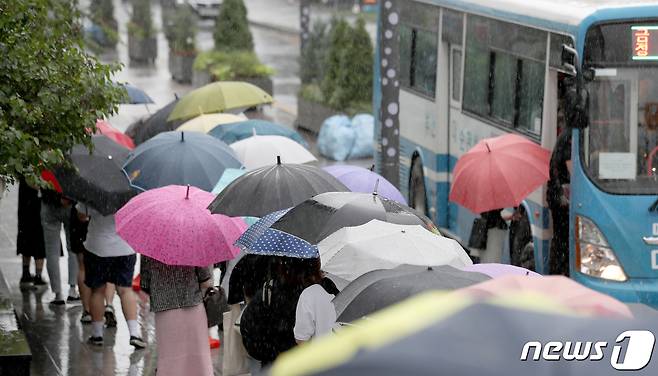 부산 금정구 부산대역 버스정류장에 우산 쓴 시민들이 버스를 타려고 줄 서 있는 모습. ⓒ News1 김영훈 기자