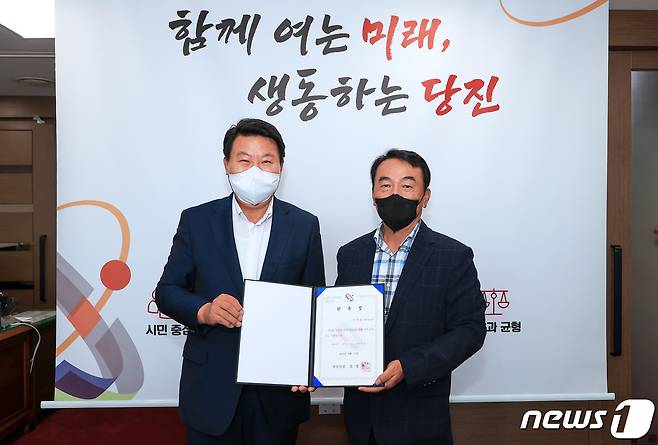 오성환 당진시장(왼쪽)이 이경중 정책특별보좌관에게 위촉장을 주고 기념촬영을 하고 있다. (당진시 재공)