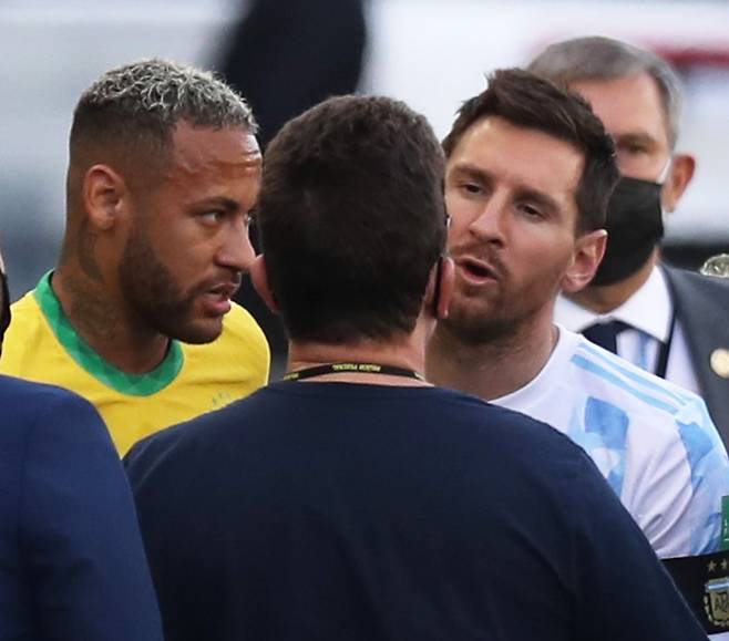 지난해 9월 6일 브라질 상파울루에서 열린 2022카타르 월드컵 남미 예선 브라질과 아르헨티나의 경기에서 아르헨티나 주장 리오넬 메시(오른쪽)가 방역 관계자와 이야기 나누는 모습을 브라질 대표팀 네이마르(왼쪽)가 지켜보고 있다. 방역 당국은 잉글랜드 프리미어리그에서 뛰는 아르헨티나 선수 4명이 코로나 관련 방역 규정을 위반했다고 지적해 이날 경기는 공식 연기됐다. /로이터