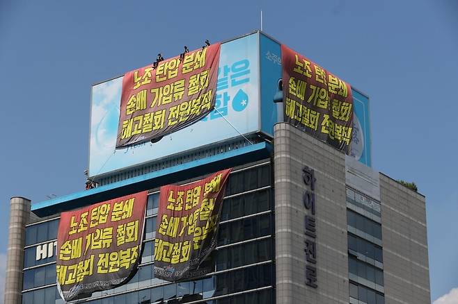 운송료 인상을 내걸고 지난 6월2일부터 파업을 벌이고 있는 공공운수노조 화물연대본부 하이트진로지부 노조원들이 16일 오후 서울 강남구 청담동 하이트진로 본사 사옥 옥상 광고판과 1층 로비를 점거하고 농성을 벌이고 있다. 강창광 선임기자 chang@hani.co.kr