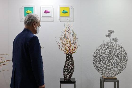 실내전시장에서 작품을 들여다보는 윤영달 크라운해태제과 회장. 윤 회장은 경쟁력 있는 한국 조각을 세계에 알려야 한다는 신념으로 이번 한각종각프로젝트를 앞장서 추진해왔다. [뉴시스]