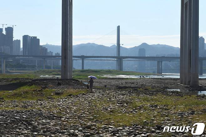 17일(현지시간) 중국 충칭에서 한 여성이 메마른 양쯔강 강바닥을 걷고 있다. 22.08.17 ⓒ 로이터=뉴스1 ⓒ News1 김예슬 기자