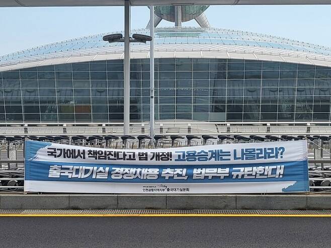 18일 인천국제공항 제1터미널 탑승장 앞에 고용승계를 요구하는 출국대기실분회 현수막이 걸려있다. 이승욱기자