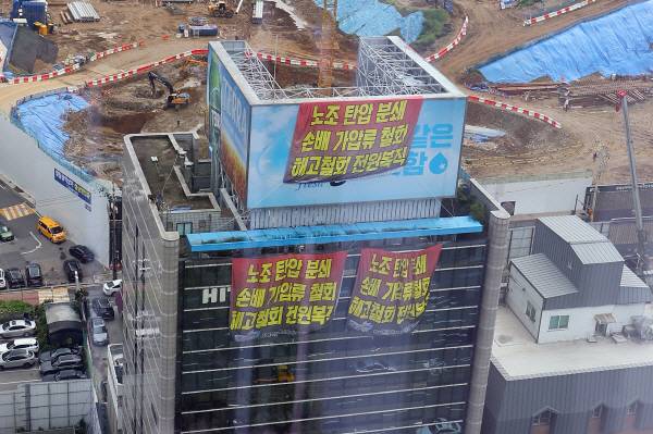 지난 16일 전국민주노동조합총연맹(민주노총) 공공운수노조 화물연대가 점거 농성 중인 서울 강남구 하이트진로 본사에 현수막이 걸려 있다. [사진 출처 = 연합뉴스]