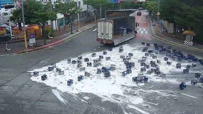 Bottles of beer fall off a truck as the driver makes a sharp turn in Chuncheon, June 29.