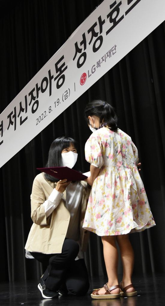 19일 서울 마곡 LG사이언스파크에서 진행된 '저신장아동 성장호르몬제 기증식'에서 구연경 LG복지재단 대표이사(왼쪽)가 어린이에게 기증서를 전달하고 있다.