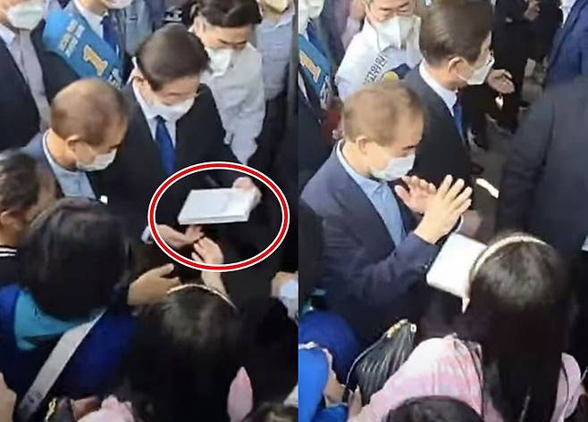 이재명 더불어민주당 대표 후보가 21일 광주 김대중컨벤션센터에서 지지자가 사인 요청을 하며 건넨 책의 표지를 본 뒤, 다시 돌려주는 모습/온라인 커뮤니티
