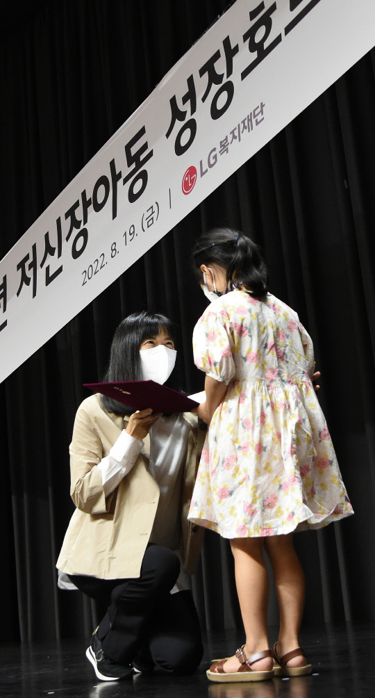 지난 19일 서울 마곡 LG사이언스파크에서 진행된 저신장아동 성장호르몬제 기증식에서 구연경(왼쪽) LG복지재단 대표이사가 어린이에게기증서를 전달하고 있다. <LG 제공>