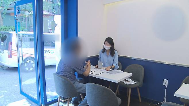 한꺼번에 건강보험료 700만 원을 부과받은 50대 남성이 취재기자와 이야기를 나누고 있다.