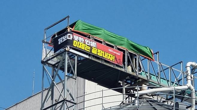 지난달 22일 전북 군산시 오식도동에 있는 참프레 공장 30ｍ 높이 저장고에서 화물 노동자들이 고공농성을 하고 있다. 이달 초부터 운송료 인상 등을 요구하며 파업을 진행 중인 노동자들은 사측의 손해배상 요구 철회를 주장하며 저장고에 올랐다. 민주노총 공공운수노조 제공