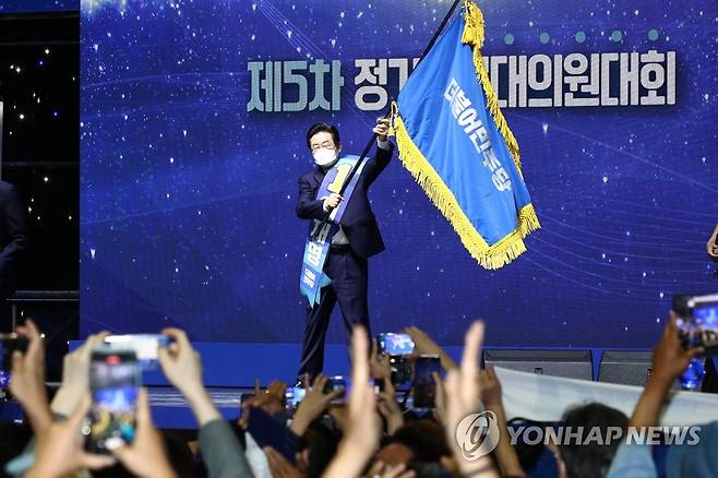당기 흔드는 민주당 이재명 신임 당 대표 (서울=연합뉴스) 더불어민주당 이재명 신임 당 대표가 28일 서울 송파구 올림픽 체조경기장에서 열린 제5차 정기전국대의원대회에서 당 대표로 선출된 뒤 당기를 흔들고 있다. 2022.8.28 [국회사진기자단] toadboy@yna.co.kr