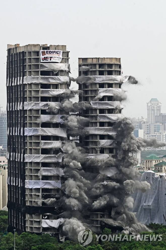 인도 아파트 철거 (노이다 AFP=연합뉴스) 28일(현지시간) 인도 뉴델리 외곽 노이다에 있는 100m 높이의 아파트 두 동이 폭탄에 의해 철거되고 있다. 2022.8.28 photo@yna.co.kr