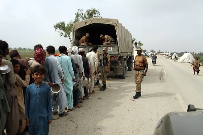 27일(현지시간)파키스탄 펀자브 지역에서 주민들이 구호품을 받기 위해 줄지어 있다. AP=연합뉴스
