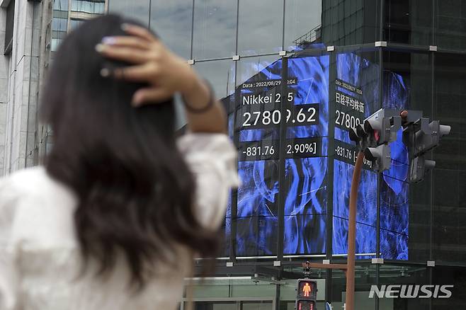 [도쿄=AP/뉴시스]29일 일본 도쿄의  증권사에서 한 시민이 일본 닛케이225 지수를 보여주는 전광판 앞에 서 있다. 제롬 파월 미국 연방준비제도(Fed·연준) 의장이 인플레이션 억제를 위해 당분간 고금리가 계속될 것이라고 밝힌 이후 아시아 증시는 월요일 하락했다. 2022.08.29.