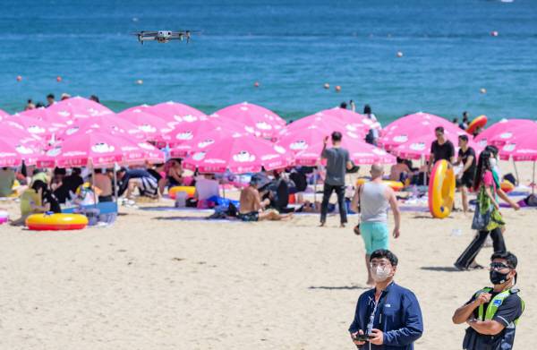 부산 해운대해수욕장에서 관광시설관리사업소 해수욕장 운영팀 관계자가 드론을 날려 해수욕장 안전을 감시하고 있다. 이원준 기자 windstorm@