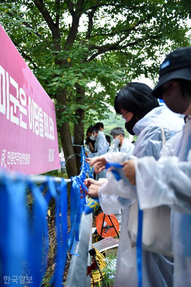 범국민평화행동 참가자들이 3일 오후 경북 성주군 초전면 소성리 진밭교 앞에서 집회가 끝난 뒤 파란색 끈을 밧줄에 묶고 있다. 류수현 기자