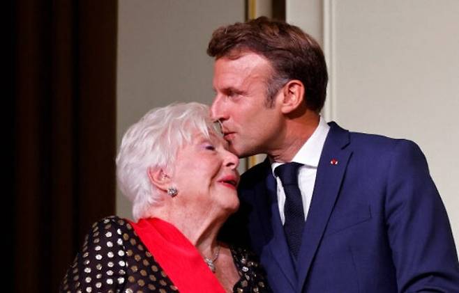 2일(현지시간) 프랑스 파리 엘리제궁에서 레종도뇌르 훈장을 받은 샹송가수 겸 영화배우 린 르노(왼쪽)에게&nbsp;에마뉘엘 마크롱 대통령이 축하의 키스를 하고 있다. 파리=AFP연합뉴스