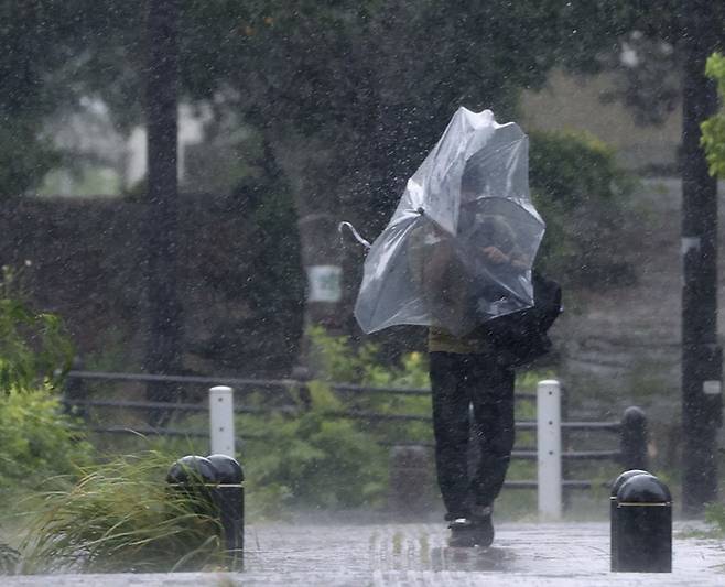 제11호 태풍 ‘힌남노’가 접근하는 가운데 3일 일본 오키나와현 나하시에서 우산을 쓴 남성이 강한 바람을 맞으며 이동하고 있다. 연합뉴스.