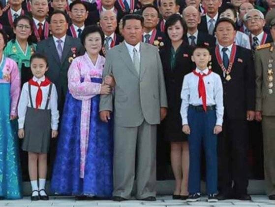 김정은 국무위원장이 지난해 9월 열병식 공로자들과 촬영한 기념사진에서 김 위원장의 팔짱을 낀 이춘히 앵커의 모습. 노동신문, 뉴스1