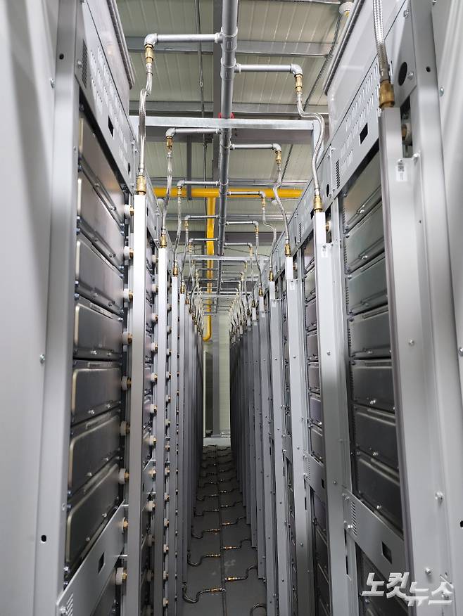 전남 신안군 안좌스마트팜앤쏠라시티 태양광발전소 내 에너지저장장치(ESS) 모습. 천장의 노란 가스관을 통해 화재 진화에 쓰이는 특수 가스가 나온다. 배터리 온도가 일정 수준(57도)을 넘길 경우 바닥부터 촘촘히 설치된 얇은 관을 통해 즉각 물을 주입해 화재 확산을 차단하게 된다. 정다운 기자