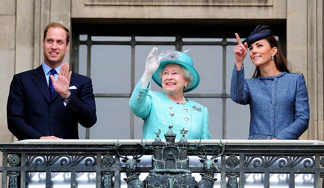 지난 2012년 6월 당시 윌리엄 왕세손(왼쪽)과 캐더린 왕세손비(오른쪽)가 엘리자베스 2세 여왕과 함께 군중을 향해 손을 흔드는 모습. /연합