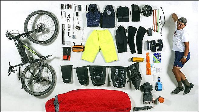 세계 최고 난이도의 무지원 바이크 패킹 레이스인 2022 실크로드 마운틴 레이스에 한국인 최초로 참가해 완주한 박종하 씨가 2일 오후 서울 마포구 중앙일보 스튜디오에서 대회 참가시 지참했던 장비들과 함께 포즈를 취하고 있다. 김성룡 기자