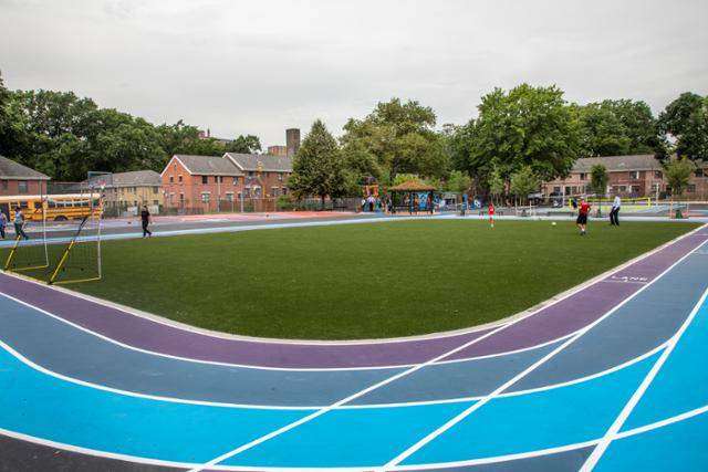 지난 7월 21일 미국 뉴욕 브롱크스 지역의 '아이칸 차터 중학교'에서 학생들이 뛰어 놀고 있습니다. 이날 새로 개장한 운동장은 비가 오면 빗물 저장고로 사용됩니다. 뉴욕시청 제공