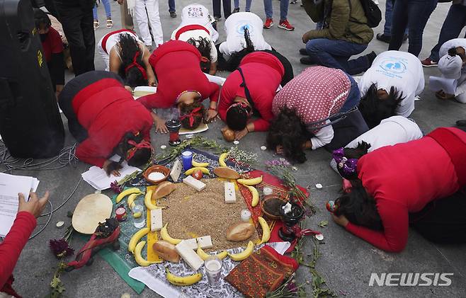 [멕시코시티= AP/뉴시스] 성직자 피살에 항의하는 행진 중에 희생자들을  위해 노제를 지내는 멕시코 원주민들.