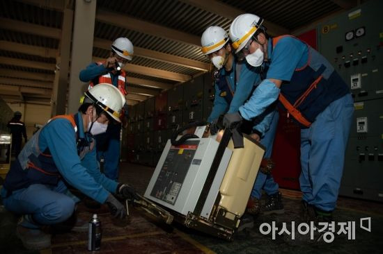 포항제철소 전력계통섹션 직원들이 침수된 고압차단기에 윤활제를 분사하고 있다.