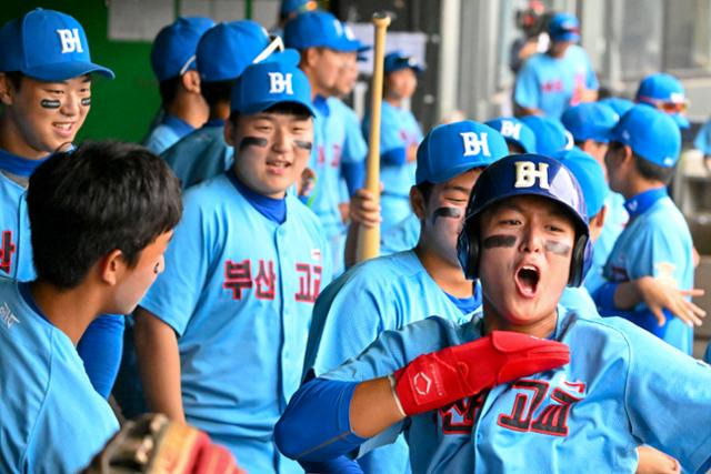 부산구 김태우(오른쪽)가 13일 서울 목동구장에서 열린 제50회 봉황대기 전국고교야구대회 결승전 강릉고와 경기에서 득점을 올린 뒤 더그아웃으로 들어와 유니폼을 뽐내는 세레모니를 하고 있다. 최주연