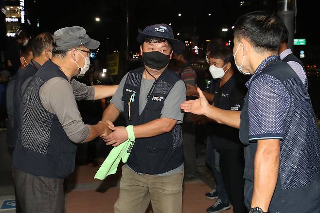 하이트진로와 전국민주노총 공공운수노조 화물연대가 노사 합의를 이뤄냈다. 지난 9일 오후 서울 강남구 하이트진로 본사 점거 고공농성을 중단하고 사옥을 빠져나와 조합원들이 격려를 받고 있다./사진=뉴스1