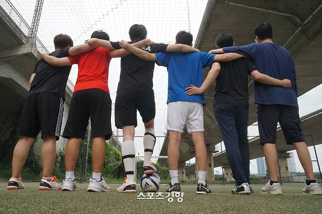 게이 축구팀 ‘FC아기오리’ 회원들이 지난 12일 서울 이촌한강공원 풋살장에서 어깨동무를 하고 있다. 이두리 기자