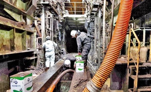 포스코는 태풍 피해로 가동이 중단된 압연 공정을 비롯한 모든 생산라인을 연말까지 정상화할 계획이다. 포항제철소 직원들이 15일 압연 라인 지하 설비에 쌓인 진흙과 펄을 제거하고 있다. /포스코 제공