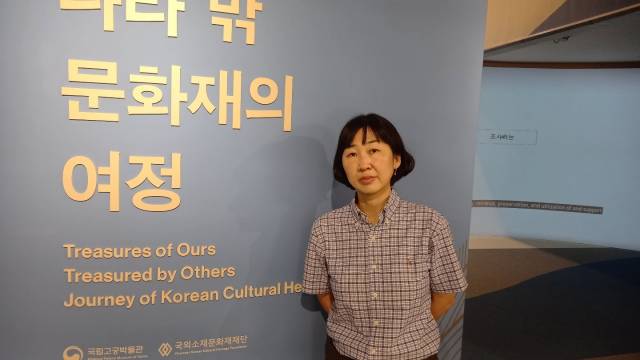 강혜승 국외소재문화재재단 유통조사부장이 서울 고궁박물관에서 열리고 있는 '나라 밖 유물의 여정' 특별전 입구에서 기념 촬영을 하고 있다.