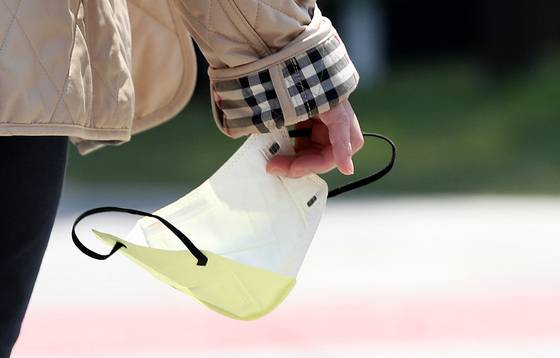 (서울=뉴스1) 박지혜 기자 = 마스크 야외 착용 의무가 해제된 첫날인 2일 서울 종로구 청계천 일대에서 한 시민이 마스크를 손에 든 채 이동하고 있다. 2022.5.2/뉴스1