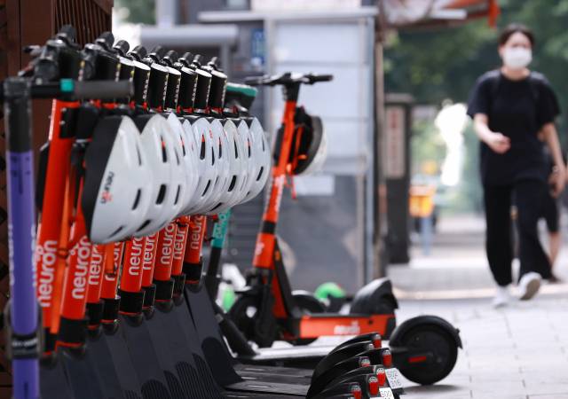 서울 강남구의 한 지하철역 앞에 안전모와 함께 전동 킥보드가 주차돼 있다. /연합뉴스