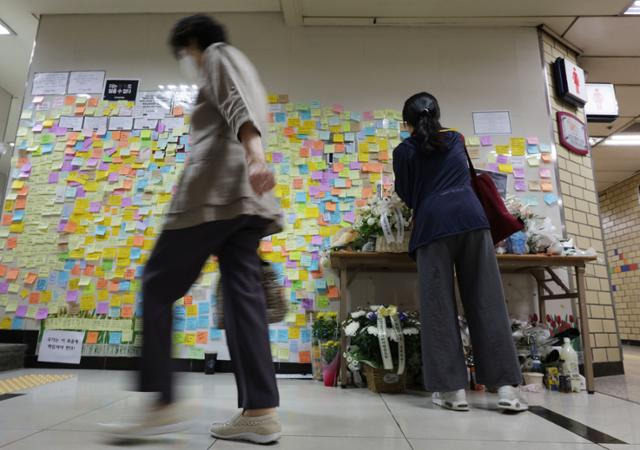 18일 '역무원 스토킹 피살 사건'이 발생한 서울 지하철 2호선 신당역 여자화장실 입구에 마련된 추모공간에서 한 시민이 추모 메시지를 남기고 있다. 연합뉴스