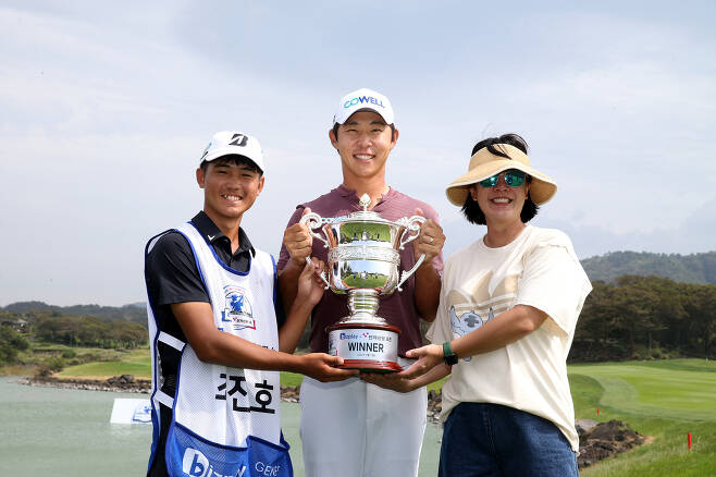 캐디(왼쪽), 부인(오른쪽)과 함께 우승컵을 들고 환하게 웃는 최진호  - KPGA 제공