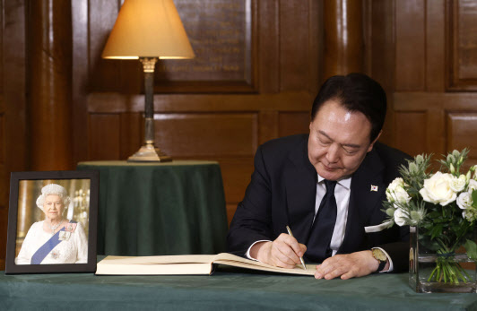 윤석열 대통령이 19일 영국 런던 웨스트민스터 사원에서 엄수된 엘리자베스 2세 여왕 장례식에 참석한 뒤 조문록을 작성하고 있다. (사진=연합뉴스)