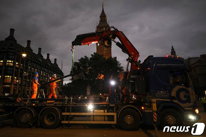 엘리자베스 2세 여왕 국장을 하루 앞둔 18일 오후(현지시간) 영국 런던 웨스트민스터 홀 인근에서 인부들이 장례 행렬을 위해 신호등을 제거하고 있다. 2022.9.19/뉴스1 ⓒ News1 안은나 기자