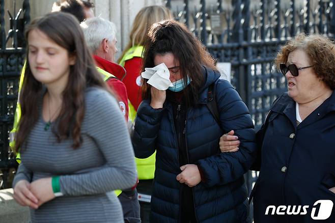 18일 오전(현지시간) 엘리자베스 2세 여왕의 관이 안치된 영국 런던 웨스트민스터 홀에서 조문을 마친 추모객이 눈물을 닦고 있다. 2022.9.18/뉴스1 ⓒ News1 안은나 기자